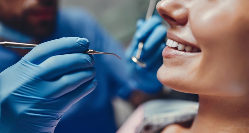 Dentysta sprawdza uzębienie swojej pacjentki za pomocą lusterka