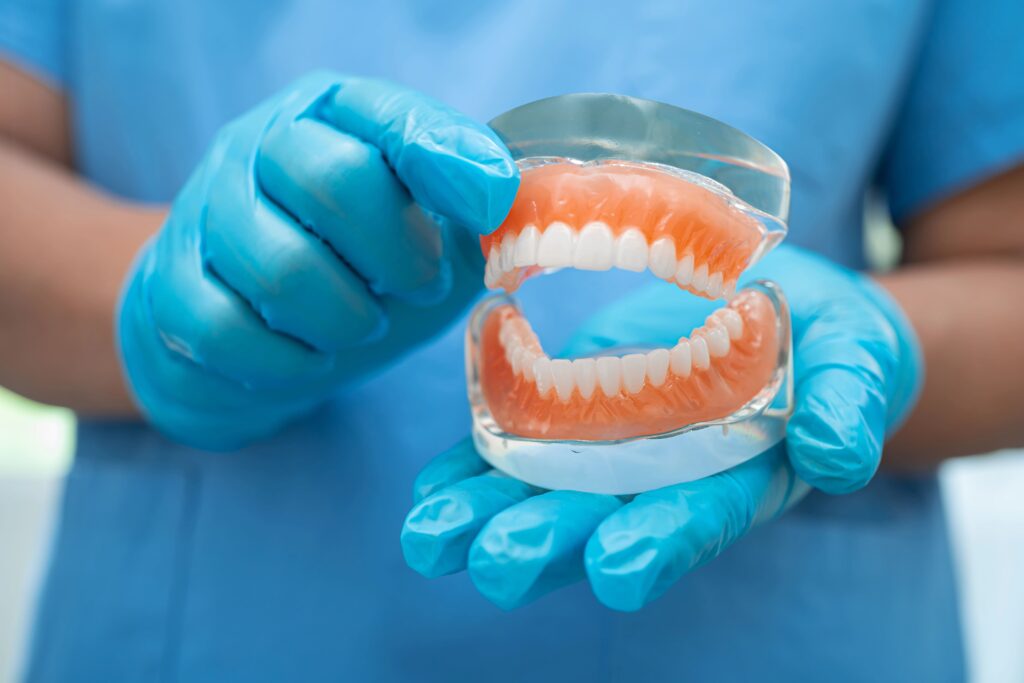 Dentysta pokazuje protezę zębową